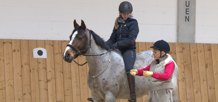 Linda Tellington Jones zeigt einer Reiterin, wie sie ihr Pferd mit Halsring reitet