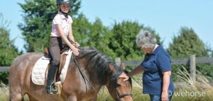 Ausbilderin Sibylle Wiemer neben Pferd und junger Reitschülerin
