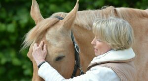 Eine Frau, die ein Pferd streichelt.