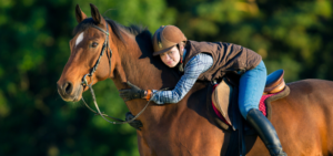 Ein Mädchen reitet auf dem Pferd und streichelt es