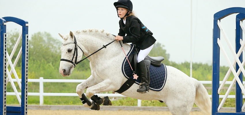 Ein Pony springt über einen Sprung.
