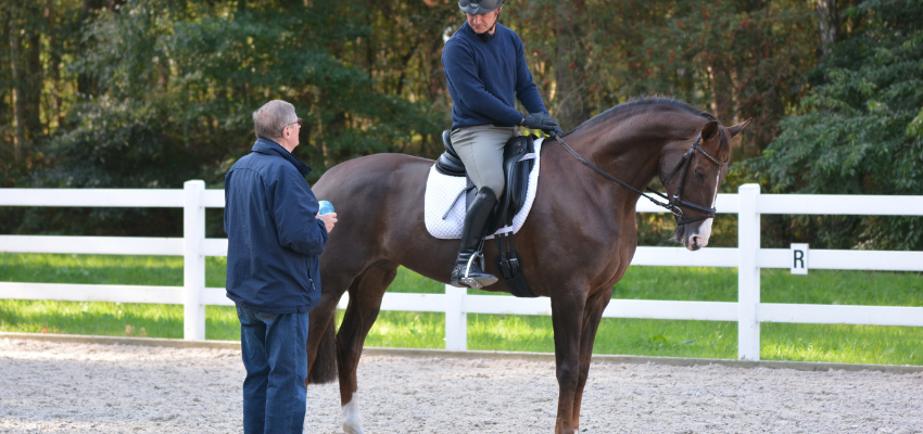 A riding instructor helping a student during a riding lesson.