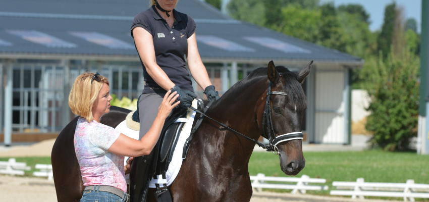 Dressage trainer Britta Schoffmann is giving a riding lesson to a student.